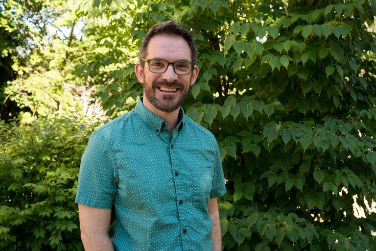 Etienne LeSage stands in front of trees