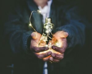 person presenting an active lightbulb in their hand to symbolize ideas